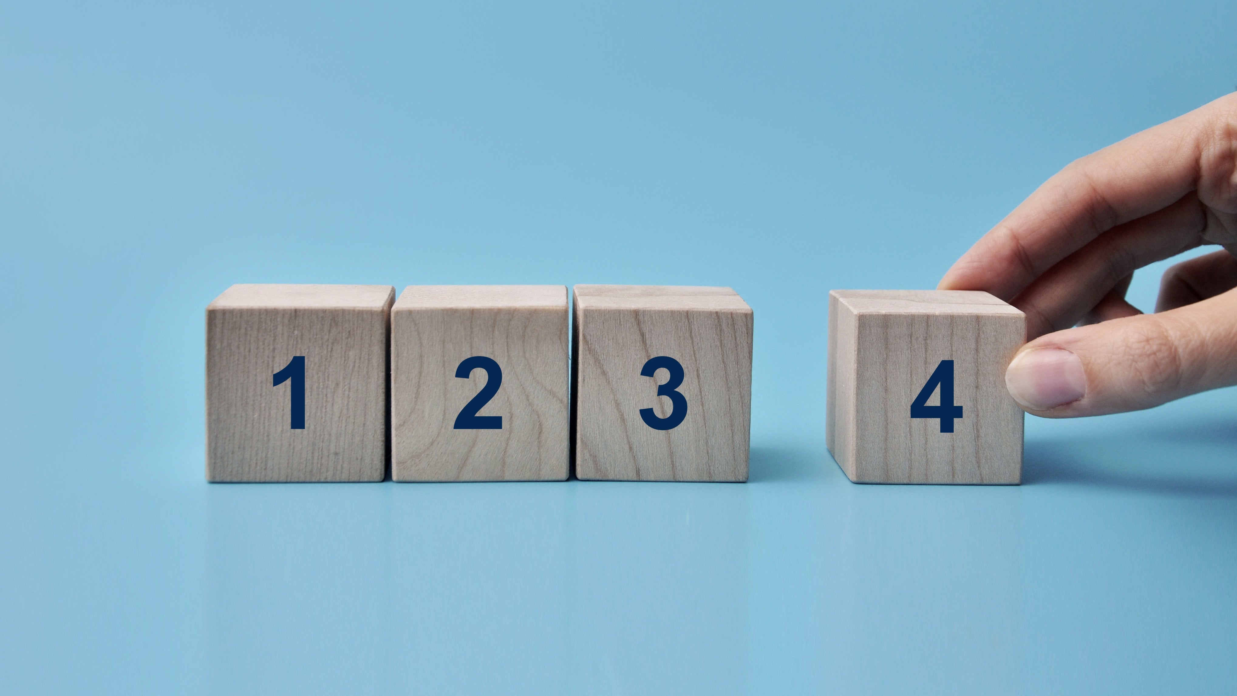 Wooden blocks with the numbers 1 to 4 on a blue background