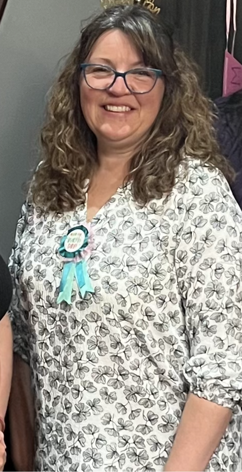 A Livy Method member before shot, wearing a tiara and a ribbon, standing against a neutral background