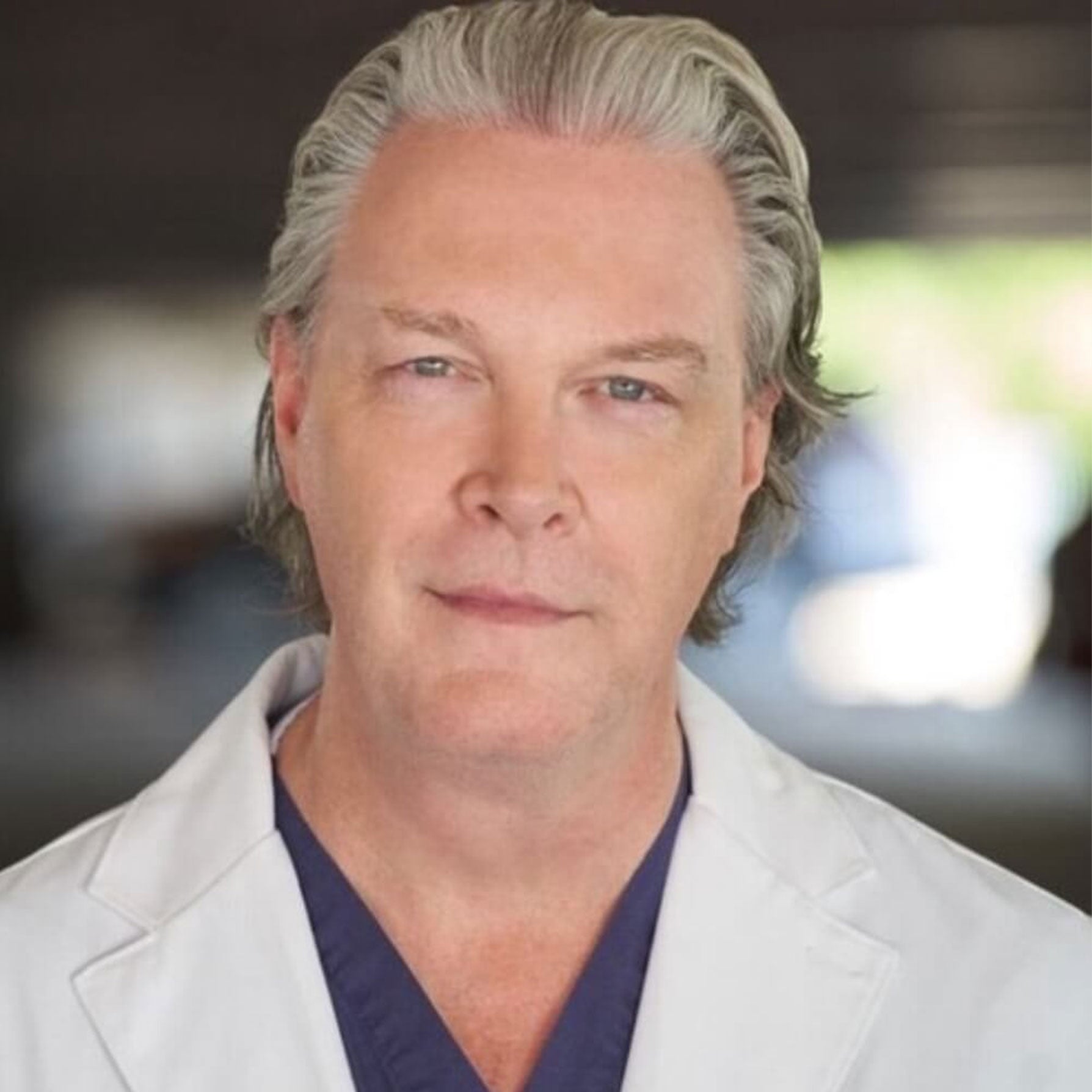 Photo of Dr. Sean Rice wearing a doctor's lab coat, looking to camera with a friendly and professional facial expression