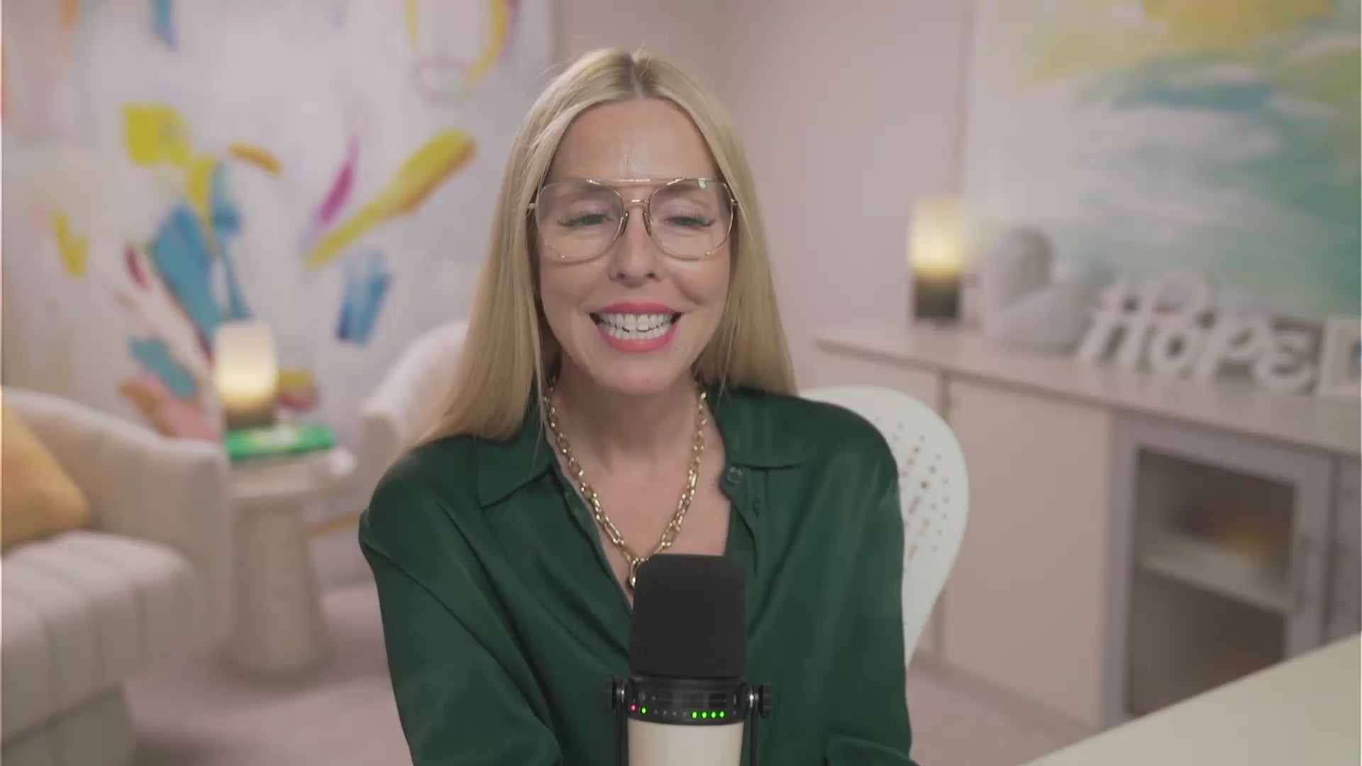 Gina addresses members from her home studio, wearing a forest green blouse