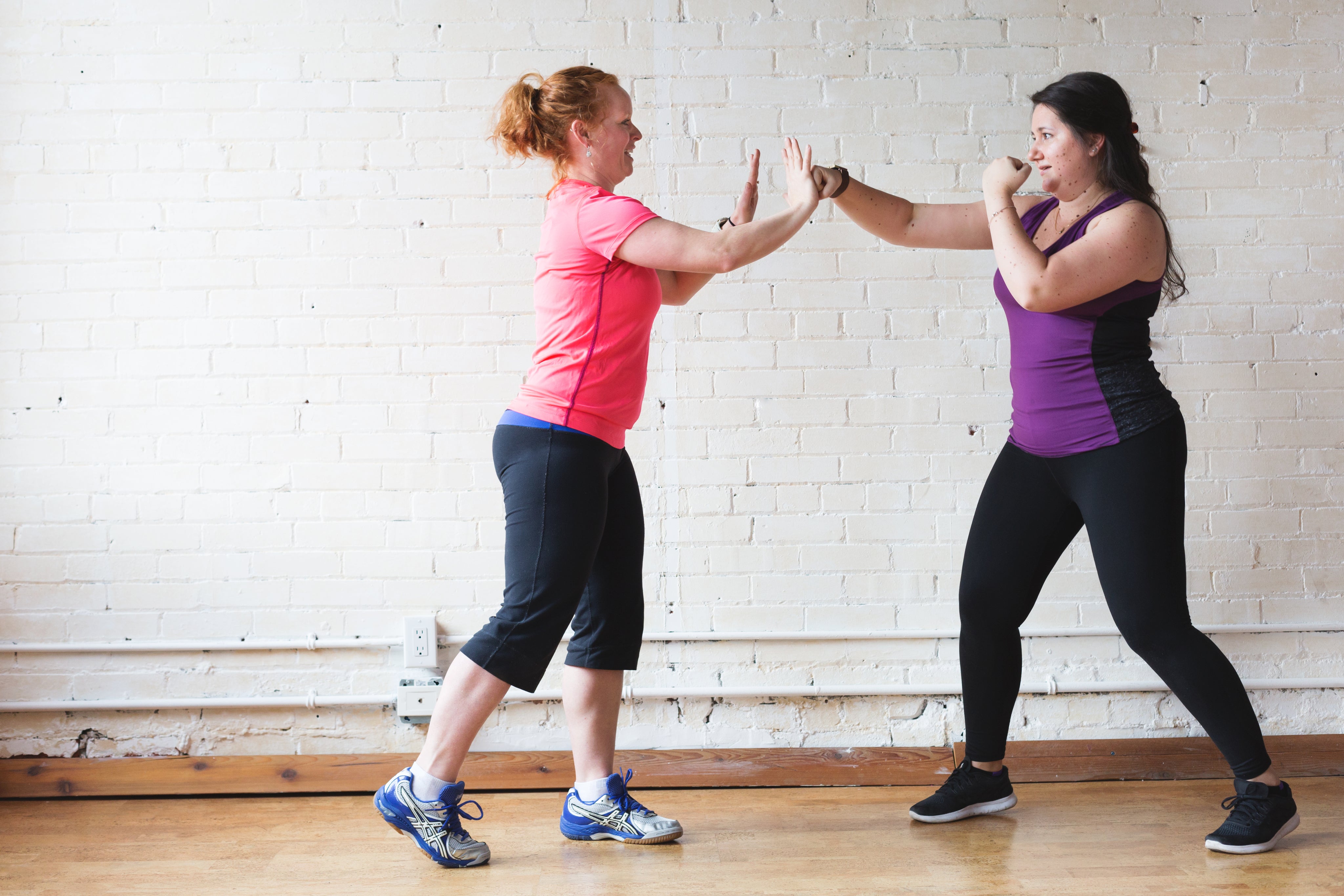 two women in workout attire practicing boxing techniques