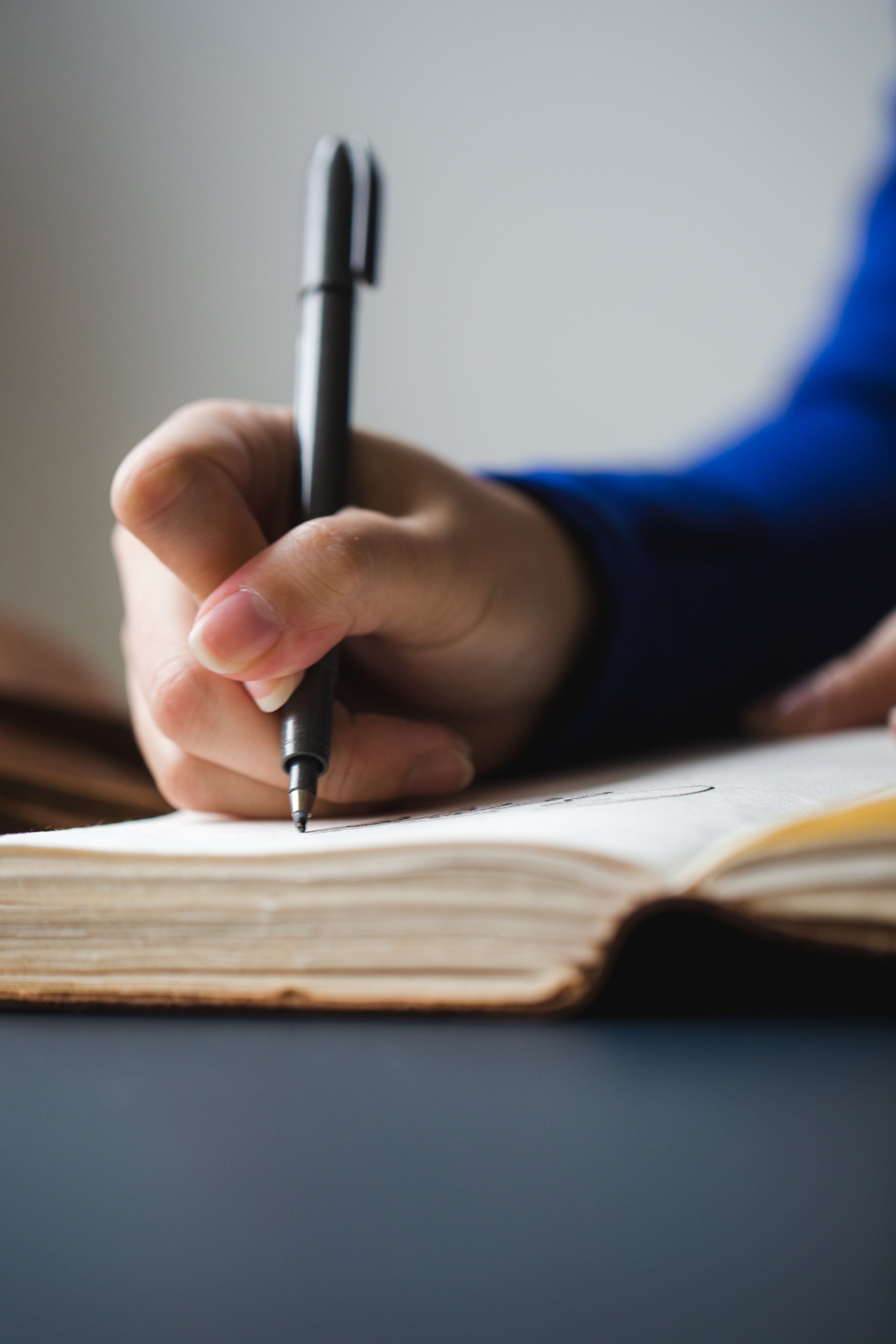 image of a hand writing in a notebook or journal
